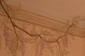 Camera decorata con finto cielo cornice e glicine